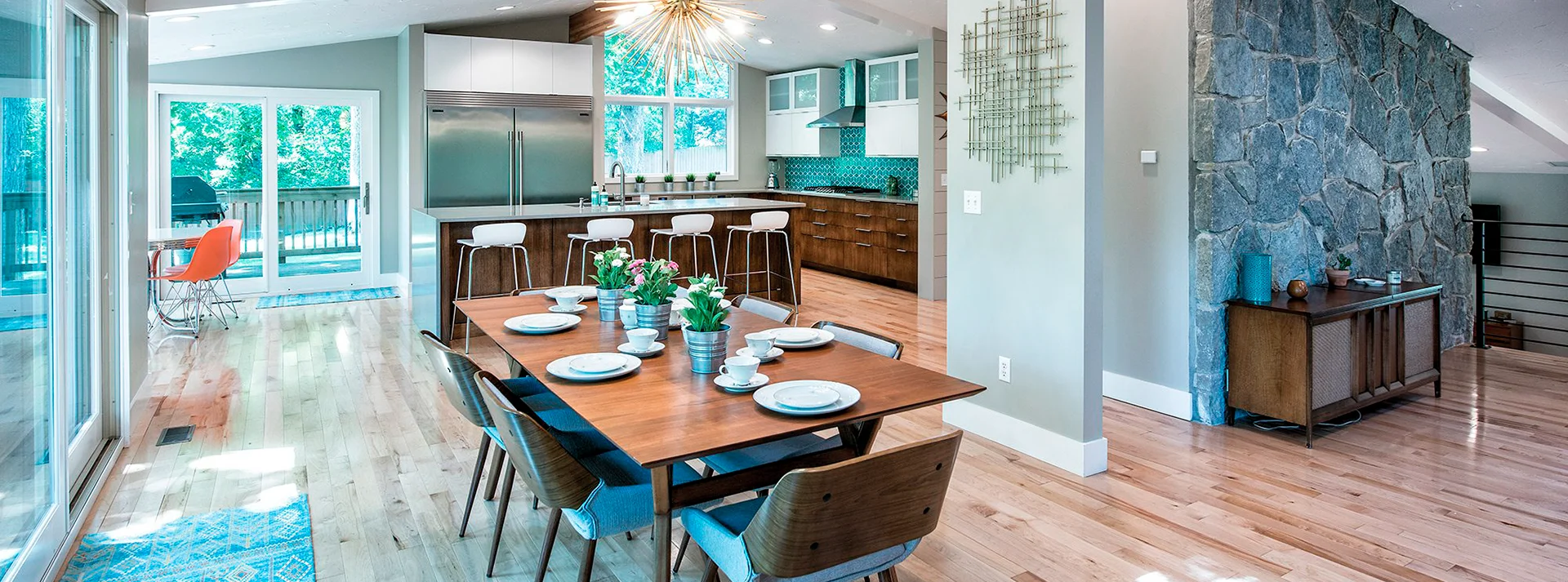 Light-filled kitchen and dining space with wood cabinetry and an island